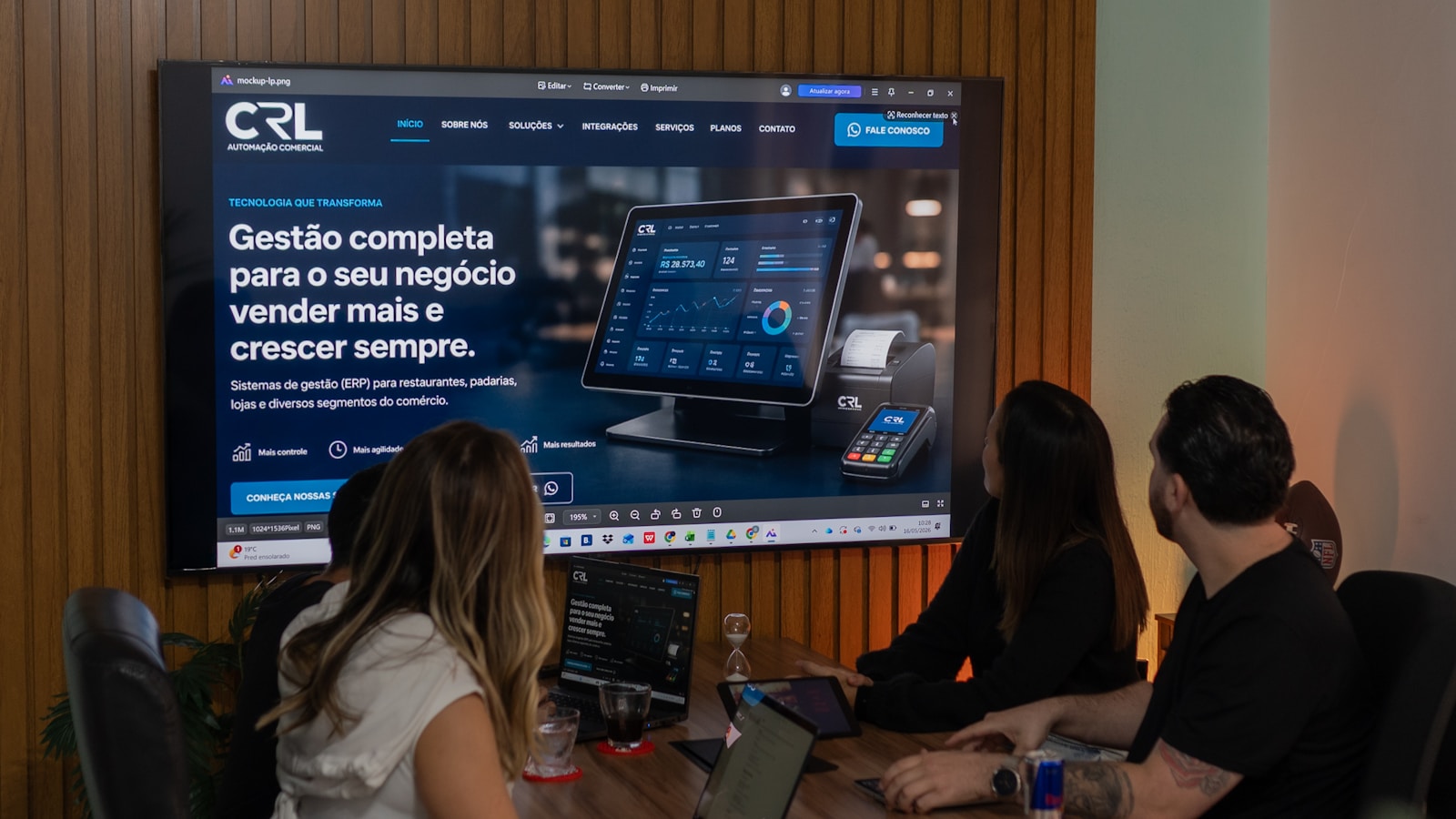 Three colleagues viewing a business presentation on a large screen.