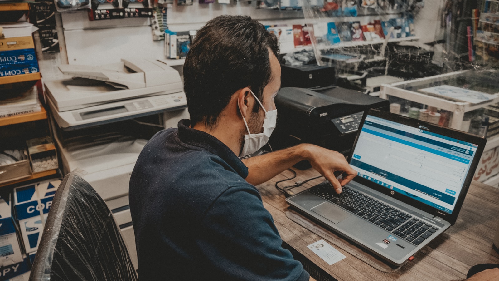 man in blue shirt using black laptop computer