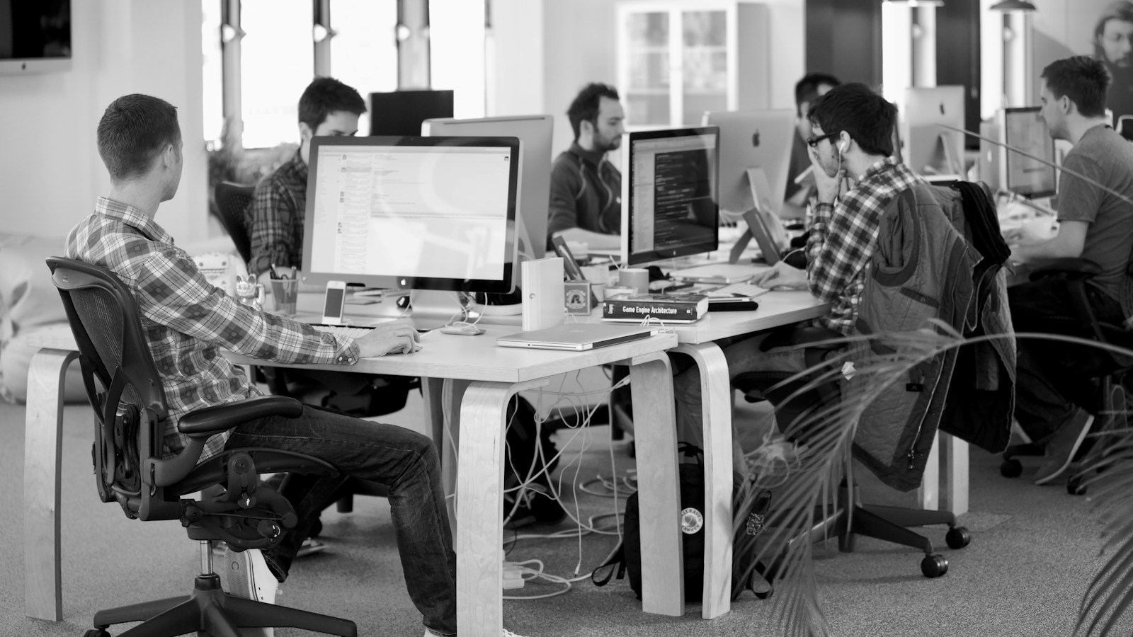 People working at computers in a bright open plan office workspace